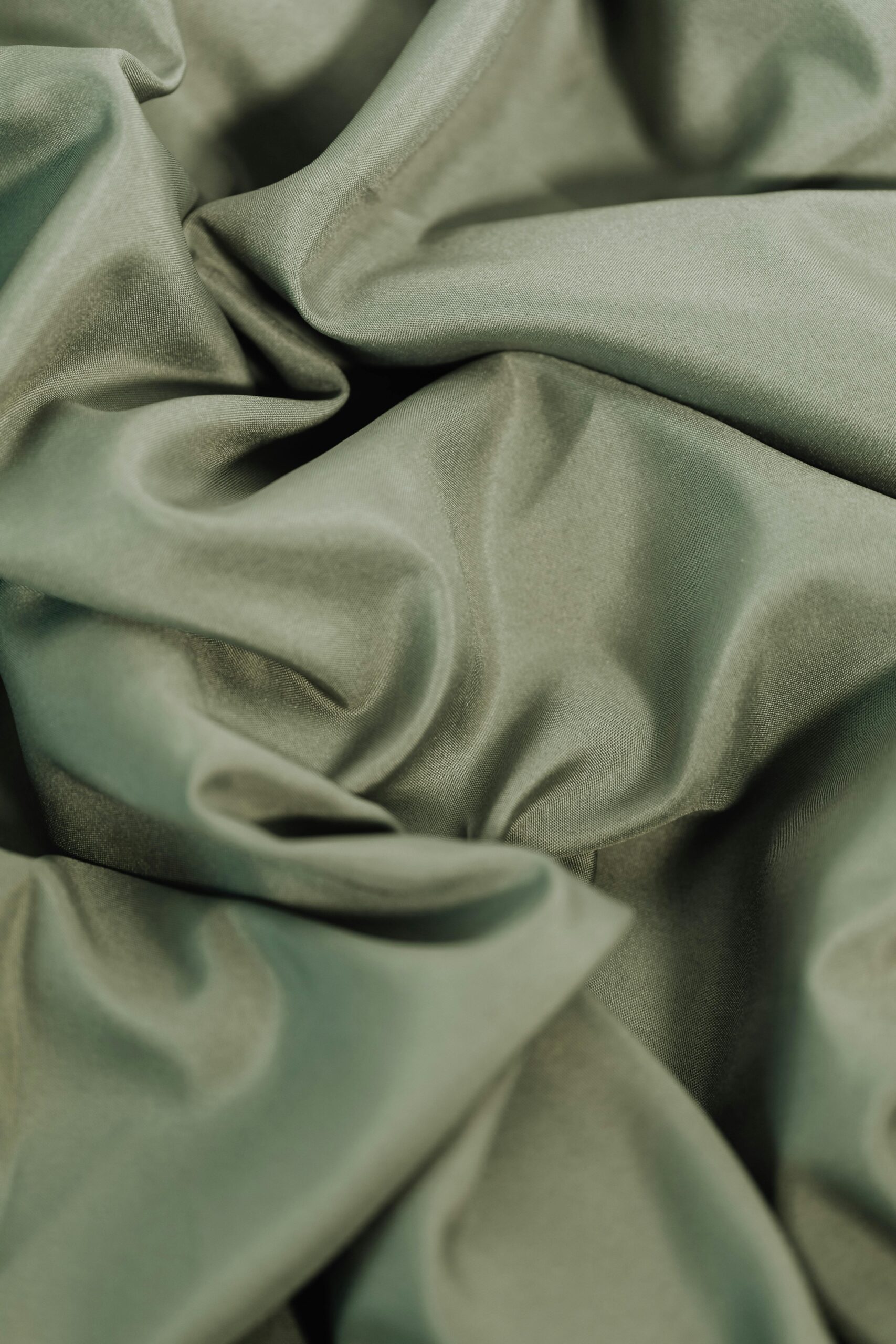 about-us Close-up of rippled, pastel green fabric texture, ideal for textile backgrounds.